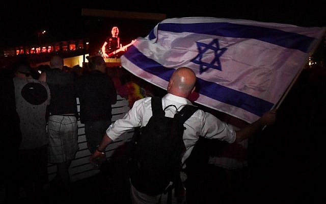 Pro-Israel supporter Paul Antey waves the Israeli flag in protest against what he says is the anti-semite political beliefs of artist Roger Waters as he performs on stage during the third day of the Desert Trip music festival at Indio, California on October 9, 2016.(AFP PHOTO / Mark RALSTON)