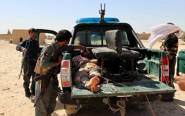 Afghan police men looks on at a body of a Taliban militant during an ongoing battle between Taliban militants and Afghan security forces in Helmand province on October 10, 2016. (photo credit: AFP/Noor Mohammad) Afghan police men looks on at a body of a Taliban militant during an ongoing battle between Taliban militants and Afghan security forces in Helmand province on October 10, 2016. (photo credit: AFP/Noor Mohammad)