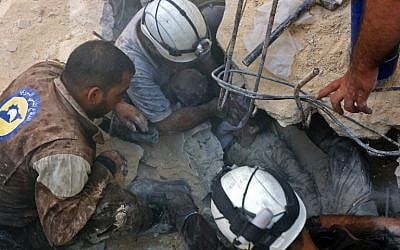 Jameel Mustafa Habboush, 13, receives oxygen from civil defence volunteers, known as the White Helmets, as they rescue him from under the rubble of a building following Russian air strikes on the rebel-held Fardous neighborhood of the northern embattled Syrian city of Aleppo on October 11, 2016. (AFP/Thaer Mohammed)