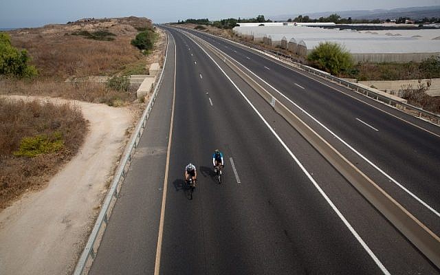 Israelis ride bicycles along an abandoned highway near Moshav Habonim in northern Israel on Yom Kippur, October 12, 2016 (AFP/Menahem Kahana)