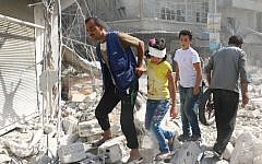 Syrians walk over rubble following air strikes on Aleppo on October 12, 2016. (AFP/Ameer Alhabli)