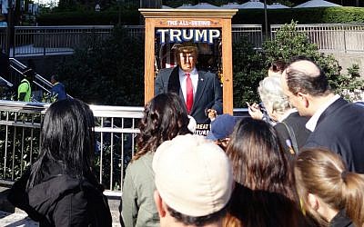 People look at the 'All-Seeing Trump', a fortune-telling fairground attraction resembling Republican presidential nominee Donald Trump, in New York on October 12, 2016. (AFP/William Edwards)