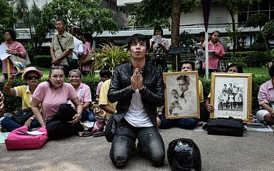 Supporters of Thailand's King Bhumibol Adulyadej pray at Siriraj Hospital, where the king was being treated, in Bangkok on October 13, 2016. (AFP PHOTO / LILLIAN SUWANRUMPHA)