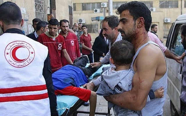 A Syrian man carries a child as they await treatment at a hospital in the regime-held part of Aleppo on October 13, 2016. (AFP/George Ourfalian) A Syrian man carries a child as they await treatment at a hospital in the regime-held part of Aleppo on October 13, 2016. (AFP/George Ourfalian)