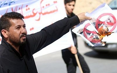 An Iraqi tribesman burns a poster bearing a portrait of Turkish President Recep Tayyip Erdogan crossed out during a protest against the continued presence of Turkish troops in northern Iraq on October 16, 2016 outside the governorate building in the southern city of Basra. (AFP PHOTO / HAIDAR MOHAMMED ALI) An Iraqi tribesman burns a poster bearing a portrait of Turkish President Recep Tayyip Erdogan crossed out during a protest against the continued presence of Turkish troops in northern Iraq on October 16, 2016 outside the governorate building in the southern city of Basra. (AFP PHOTO / HAIDAR MOHAMMED ALI)