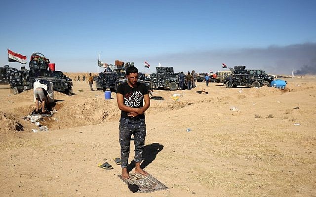 A Sunni Iraqi policeman prays at the Qayyarah military base, about 60 kilometers (35 miles) south of Mosul, on October 16, 2016, as they prepare for an offensive to retake the last IS-held city in the country. (AFP PHOTO/AHMAD AL-RUBAYE)