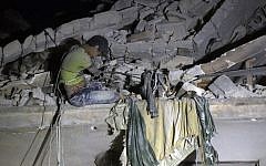 Maarouf, a 12-year-old Syrian boy waits to be rescued from the rubble of a building following a reported air strike on the the rebel-held Qaterji neighborhood of Aleppo on October 16, 2016. (AFP PHOTO/THAER MOHAMMED)