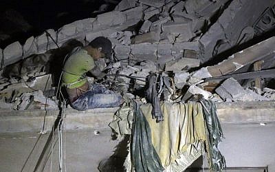 Maarouf, a 12-year-old Syrian boy waits to be rescued from the rubble of a building following a reported air strike on the the rebel-held Qaterji neighborhood of Aleppo on October 16, 2016. (AFP PHOTO/THAER MOHAMMED)