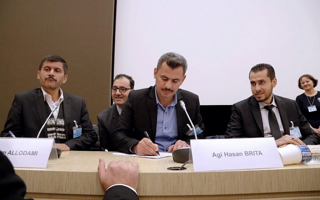 Hagi Hasan Brita, president of the civil committee of Aleppo (C), Abdulrahman Almawwas (R), vice-president of the Syrian White Helmets, and Tammam Allodami, a member of the White Helmets, take part in a meeting at the National Assembly in Paris on October 18, 2016. (AFP PHOTO/FRANCOIS GUILLOT)