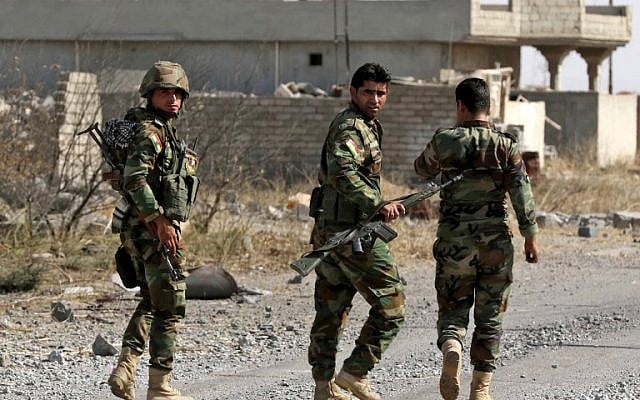 Iraqi Kurdish peshmerga fighters patrol on October 18, 2016 in the Shaqouli village, about 35 kilometers east of Mosul, after they've recaptured it from the Islamic State (IS) group jihadists. (SAFIN HAMED/AFP)