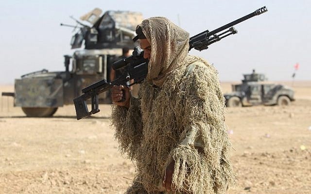 An Iraqi forces member dressed in a camouflage outfit walks in the Bajwaniyah village, about 30 kilometers south of Mosul, on October 18, 2016 as the forces advance to liberate Mosul from the Islamic State (IS) group jihadists. (AFP PHOTO / AHMAD AL-RUBAYE)