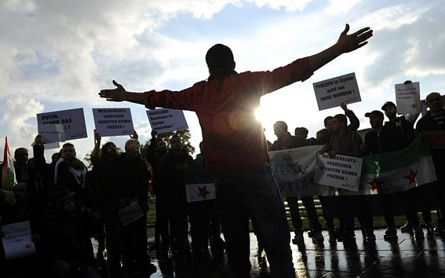 Protesters hold signs during a demonstration against the bombings in Aleppo on October 19, 2016 in front of the chancellery in Berlin, ahead of a meeting of leaders of Russia, Ukraine, France and Germany. (AFP PHOTO/STEFFI LOOS)