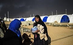 Smoke billows behind Iraqis as they arrive at refugee camp in the town of Qayyarah, south of Mosul, on October 22, 2016 (AFP/Bulent Kilic)