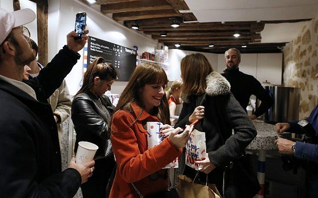 Customers leave after buying popcorn at the opening of the Yummy Pop gourmet popcorn shop in the Marais district of Paris on October 22, 2016, a joint effort of US actress Scarlett Johansson and her French husband, advertising executive Romain Dauriac. (Benjamin Cremel/AFP)