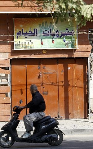 An Iraqi man drives past a closed liquor store in the capital Baghdad on October 23, 2016. (AFP PHOTO / SABAH ARAR)