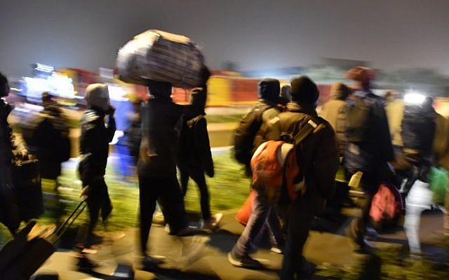 Migrants line up for transportation by bus to reception centers across France, from the "Jungle" migrant camp in Calais, northern France, on October 24, 2016. (AFP PHOTO / PHILIPPE HUGUEN)