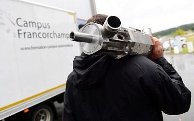 Gal Fridman, the co-founder of Aquarius Engines carries a single-piston car engine invented by Shaul Yakobi, at Campus Automobile Spa-Francorchamps in Belgium on October 19, 2016. (AFP PHOTO/EMMANUEL DUNAND)