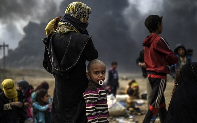 Iraqi families who were displaced by the ongoing operation by Iraqi forces against jihadists of the Islamic State group to retake the city of Mosul, are seen gathering in an area near Qayyarah on October 24, 2016. (AFP PHOTO / BULENT KILIC)