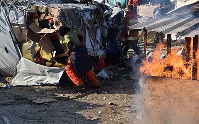Workers begin the demolition of the Calais "Jungle" camp, in Calais, northern France, on October 25, 2016 as hundreds of migrants boarded buses on the second day of a massive operation to clear the squalid settlement. ( AFP PHOTO / PHILIPPE HUGUEN)