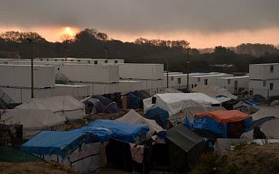 A picture taken on October 26, 2016 shows makeshift shelters and tents of the "Jungle" migrant camp in Calais, northern France, next to shipping containers housing migrants during the demolition of the camp.
(AFP / Philippe Huguen)