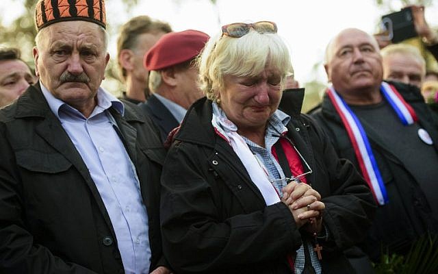 A woman cries during a ceremony marking the beginning of the burial of remains of some 800 people killed by communist forces after World War II at the Dobrava Memorial Park in Maribor, on October 27, 2016. (AFP PHOTO/Jure MAKOVEC)