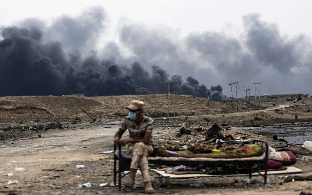 An Iraqi soldier sits at a checkpoint in an area near Qayyarah on October 28, 2016, as he waits for families who were displaced by the ongoing operation by Iraqi forces against jihadists of the Islamic State group to retake the city of Mosul. (AFP PHOTO / BULENT KILIC) An Iraqi soldier sits at a checkpoint in an area near Qayyarah on October 28, 2016, as he waits for families who were displaced by the ongoing operation by Iraqi forces against jihadists of the Islamic State group to retake the city of Mosul. (AFP PHOTO / BULENT KILIC)