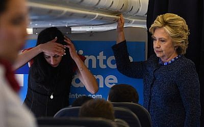 US Democratic presidential nominee Hillary Clinton (R) talks to her staff as aide Huma Abedin listens on board their campaign plane at the Westchester County Airport in White Plains, New York, before leaving for campaign rallies on October 28, 2016. (AFP PHOTO/Jewel SAMAD)
