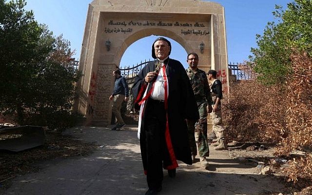 Archbishop Yohanna Petros Mouche of Mosul inspects the damage at the Saint Barbara Church on October 30, 2016 in the town of Qaraqosh (also known as Hamdaniya), 30 kms east of Mosul, after Iraqi forces recaptured it from Islamic State (IS) group jihadists. (AFP / SAFIN HAMED) Archbishop Yohanna Petros Mouche of Mosul inspects the damage at the Saint Barbara Church on October 30, 2016 in the town of Qaraqosh (also known as Hamdaniya), 30 kms east of Mosul, after Iraqi forces recaptured it from Islamic State (IS) group jihadists. (AFP / SAFIN HAMED)