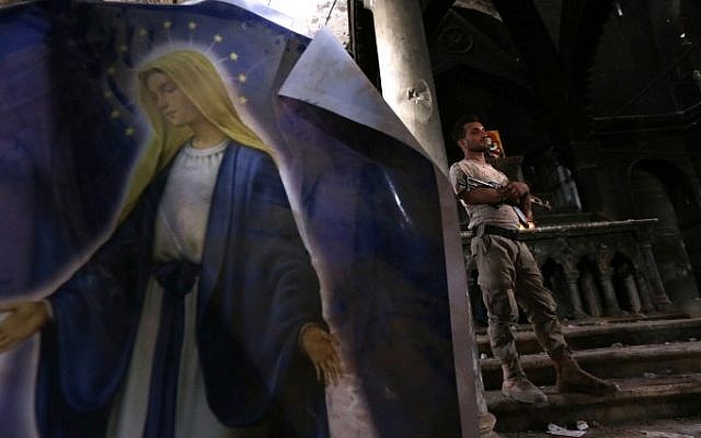 An Iraqi forces member stands in the Church of the Immaculate Conception on October 30, 2016 in the town of Qaraqosh (also known as Hamdaniya), 30 kms east of Mosul, after Iraqi forces recaptured it from Islamic State (IS) group jihadists. (AFP/ SAFIN HAMED) An Iraqi forces member stands in the Church of the Immaculate Conception on October 30, 2016 in the town of Qaraqosh (also known as Hamdaniya), 30 kms east of Mosul, after Iraqi forces recaptured it from Islamic State (IS) group jihadists. (AFP/ SAFIN HAMED)