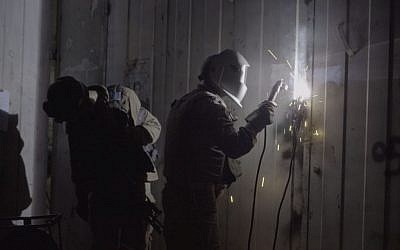 IDF soldiers weld shut the doors of an alleged gunsmithing workshop in the Palestinian village of Azzun, in the northern West Bank, on October 10, 2016. (IDF Spokesperson's Unit) IDF soldiers weld shut the doors of an alleged gunsmithing workshop in the Palestinian village of Azzun, in the northern West Bank, on October 10, 2016. (IDF Spokesperson's Unit)