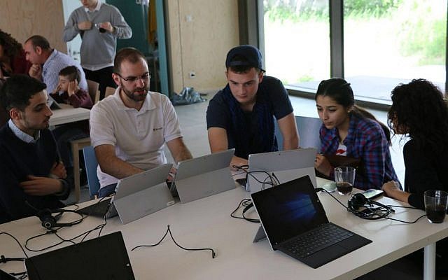 Hillel Zand (center) assists Middle Eastern refugees at a computer skills seminar in Berlin, summer 2016. (Hillel Zand) Hillel Zand (center) assists Middle Eastern refugees at a computer skills seminar in Berlin, summer 2016. (Hillel Zand)