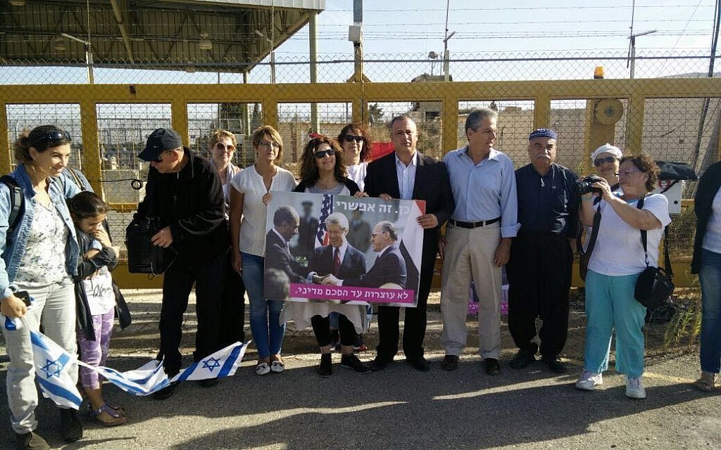 MK Hilik Bar (4th right) attends an anti-war protest at the Quneitra Crossing on the Syrian border, October 18, 2016.  Bar is holding a poster of Sadat, Carter and Begin clasping hands at the White House signing of a 1979 Israel-Egypt peace treaty.