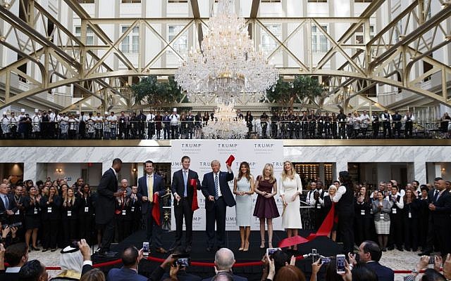 Republican nominee Donald Trump, accompanied by members of his family, holds up a ribbon during the grand opening ceremony of the Trump International Hotel- Old Post Office (Evan Vucci/AP) Republican nominee Donald Trump, accompanied by members of his family, holds up a ribbon during the grand opening ceremony of the Trump International Hotel- Old Post Office (Evan Vucci/AP)