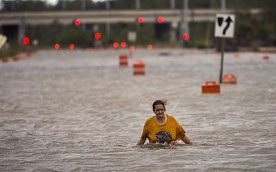 A woman who identified herself as Valerie walks along flooded President Street after leaving her homeless camp after Hurricane Matthew caused flooding, Saturday, Oct. 8, 2016, in Savannah, Georgia. (AP Photo/Stephen B. Morton) 