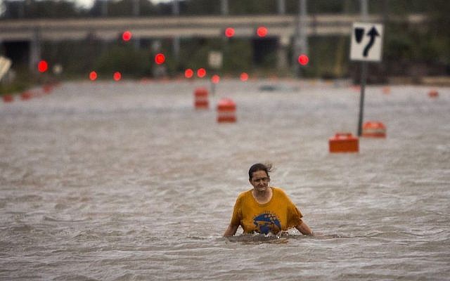A woman who identified herself as Valerie walks along flooded President Street after leaving her homeless camp after Hurricane Matthew caused flooding, Saturday, Oct. 8, 2016, in Savannah, Georgia. (AP Photo/Stephen B. Morton) 
