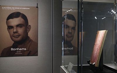 FILE - In this Thursday, March 19, 2015 file photo, a notebook of British mathematician and pioneer in computer science Alan Turing, the World War II code-breaking genius, is displayed in front of his portrait during an auction preview in Hong Kong. (Kin Cheung/AP)