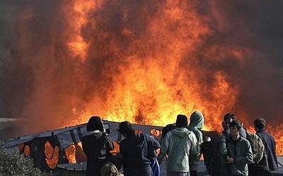 Thick smoke and flames rise from amidst the tents after fires were started in the makeshift migrant camp known as "the jungle" near Calais, northern France, Wednesday, October 26, 2016. Firefighters have doused several dozen fires set by migrants as they left the makeshift camp where they have been living near the northern French city of Calais. (AP Photo/Emilio Morenatti)