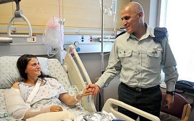 Cpt. Or Ben-Yehuda shakes hands with former head of the IDF's Southern Command Maj. Gen. Sami Turgeman while she was recuperating from wounds sustained in an attack by smugglers in October 2014. (IDF Spokesperson's Unit)