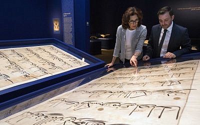 In this photo taken Oct. 20, 2016, Massumeh Farhad, left, and Simon Rettig, curators of the exhibit "The Art of the Qur'an: Treasures from the Museum of Turkish and Islamic Arts," look at pages from a 5-foot by 7-foot Quran displayed as part of the exhibit at the Sackler Gallery in Washington. (AP/Molly Riley)