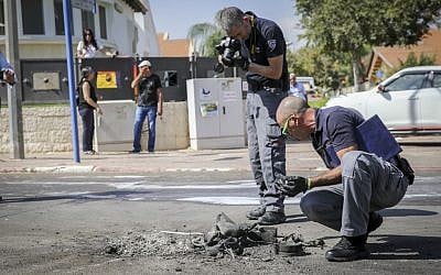 Police sappers dig out piece of a rocket launched from the Gaza Strip that struck a road in the southern city of Sderot on October 5, 2016. ( FLASH90) 