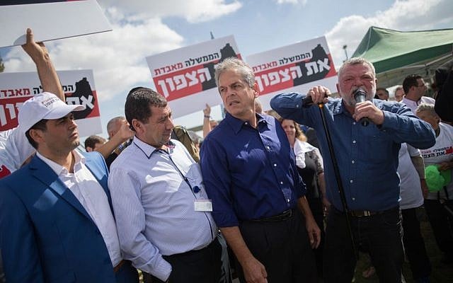 Meretz MK Ilan Gilon (right) speaks during a protest by residents of northern Israel at the Knesset in Jerusalem on October 31, 2016, against proposed budget cuts for their communities. The banners read: 'The government is losing the north.' (Photo by Yonatan Sindel/Flash90)