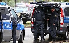 Police officers surround an apartment in the eastern city of Chemnitz, Germany, Saturday Oct. 8, 2016. (Nonstop News via AP)