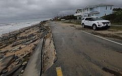 An official vehicle passes along the shoulder of Highway A1A after it was partial washed away by Hurricane Matthew, Friday, Oct. 7, 2016, in Flagler Beach, Florida (AP Photo/Eric Gay)