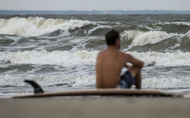 Eric Dunn sits on the northern end of Tybee Island's beach watching larger than average waves roll in as a result of Hurricane Matthew's approach, Tuesday, Oct. 4, 2016 in Tybee Island, Georgia. (Josh Galemore/Savannah Morning News via AP) Eric Dunn sits on the northern end of Tybee Island's beach watching larger than average waves roll in as a result of Hurricane Matthew's approach, Tuesday, Oct. 4, 2016 in Tybee Island, Georgia. (Josh Galemore/Savannah Morning News via AP)