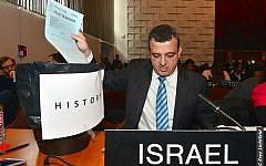 Israel's ambassador to UNESCO Carmel Shama-Hacohen throws a copy of the day's resolution on Jerusalem in the trash, October 26, 2016. (Erez Lichtfeld)