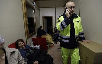 Mayor of Visso Giuliano Pazzaglini speaks over the phone in the offices of the Italian Red Cross, crowded with residents after a 5.9 earthquake destroyed part of their neighborhood in Visso, central Italy, October 27, 2016. (AP/Alessandra Tarantino) 