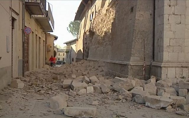 In this image made from video, bricks fallen from a damaged building block a street in Norcia, Italy on Sunday, Oct. 30, 2016 after a powerful earthquake with a preliminary magnitude of 6.6 rocked central and southern Italy following a week of temblors left thousands homeless. (Sky Italia via AP)