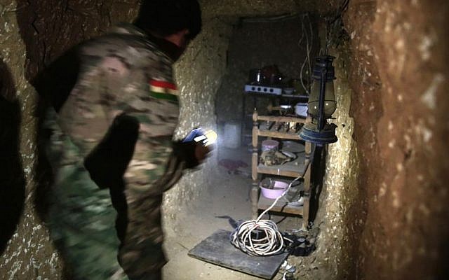 A peshmerga fighter walks through the kitchen of an underground tunnel made by Islamic State fighters, Tuesday, Oct. 18, 2016. (AP/Bram Janssen)