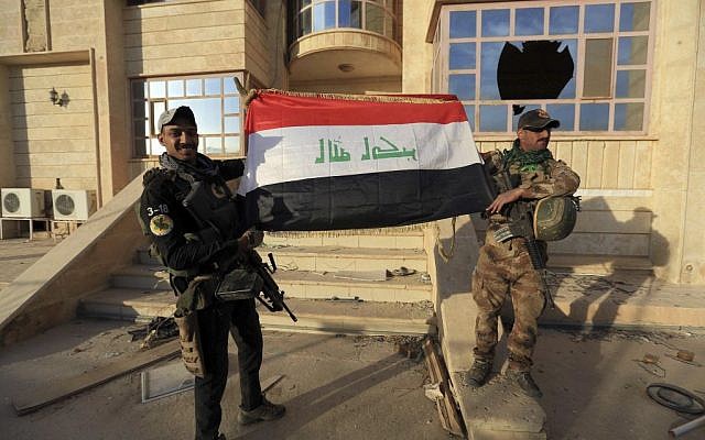 Iraq's elite counterterrorism force soldiers raise an Iraqi flag in front of the main church in Bartella, Iraq, Friday, Oct. 21, 2016. By Thursday, the Iraqi forces had advanced as far as Bartella, a historically Christian town some nine miles (15 kilometers) from Mosul's outskirts. (AP Photo/Khalid Mohammed) Iraq's elite counterterrorism force soldiers raise an Iraqi flag in front of the main church in Bartella, Iraq, Friday, Oct. 21, 2016. By Thursday, the Iraqi forces had advanced as far as Bartella, a historically Christian town some nine miles (15 kilometers) from Mosul's outskirts. (AP Photo/Khalid Mohammed)
