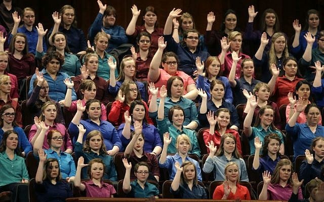 In this April 2, 2016, file photo, members of the combined Choir from BYU-Idaho raise their hands during a sustaining vote at the two-day Mormon church conference in Salt Lake City, Utah. (AP Photo/Rick Bowmer, File)